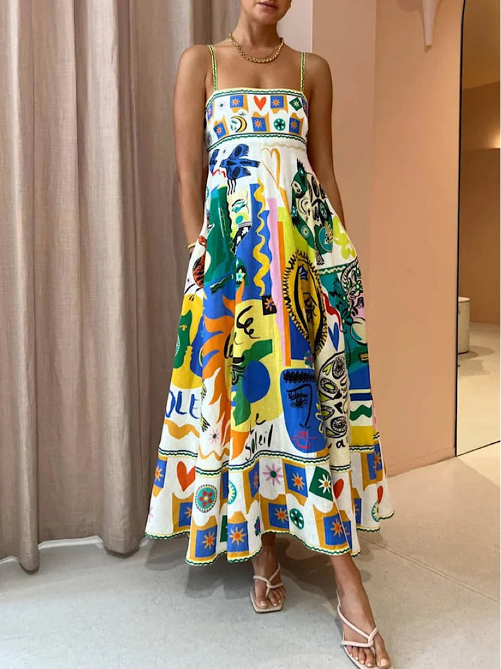 Women's abstract print maxi sundress with thin straps. Flowing, vibrant summer style perfect for vacation.