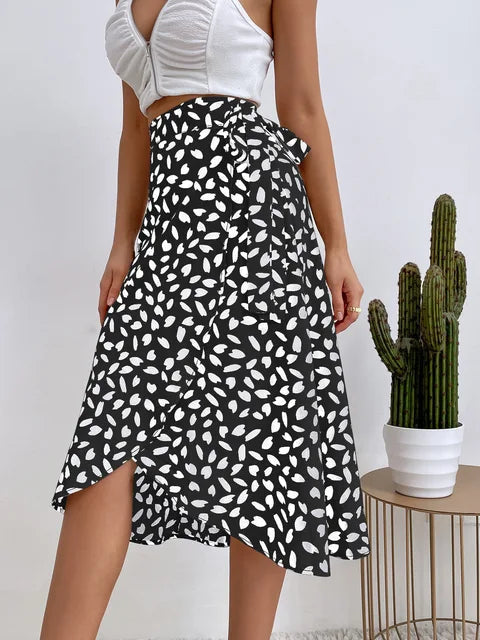 Close-up of women's flowy animal print midi skirt, showcasing tie waist detail and stylish asymmetric hem.