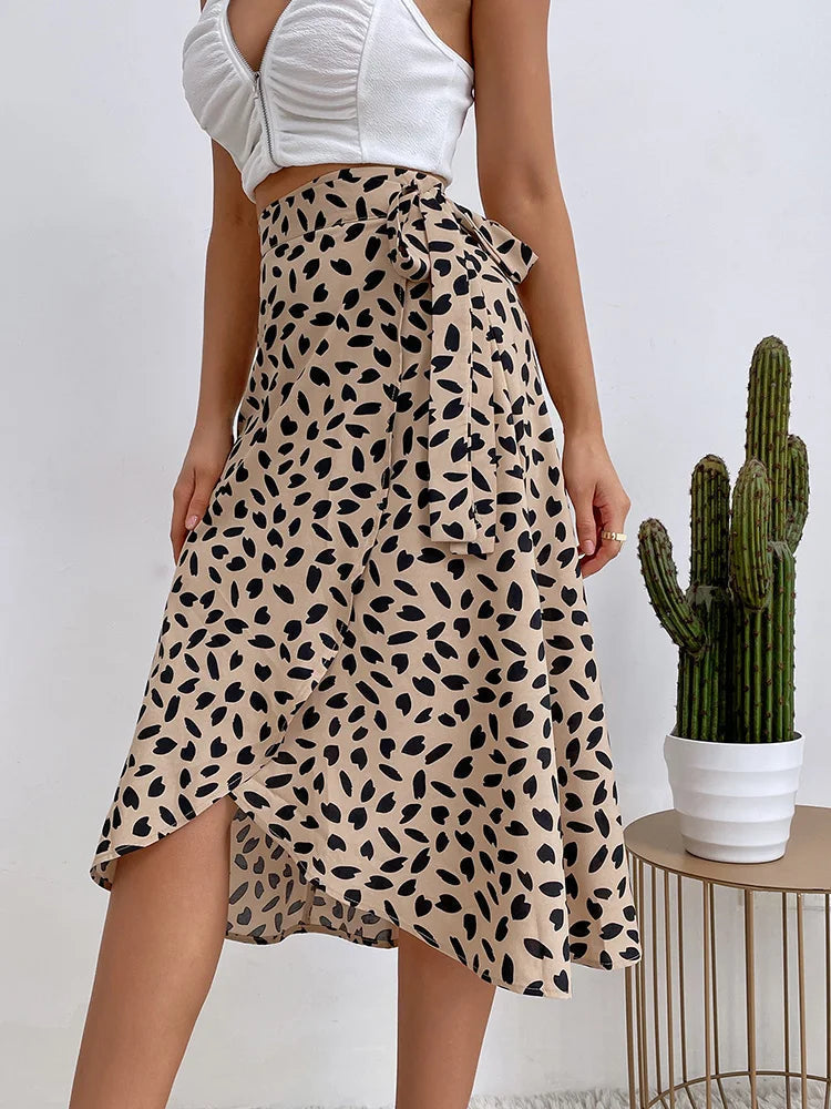 Women's flowy animal print midi skirt with tie waist and asymmetric hem, perfect for spring/summer fashion.