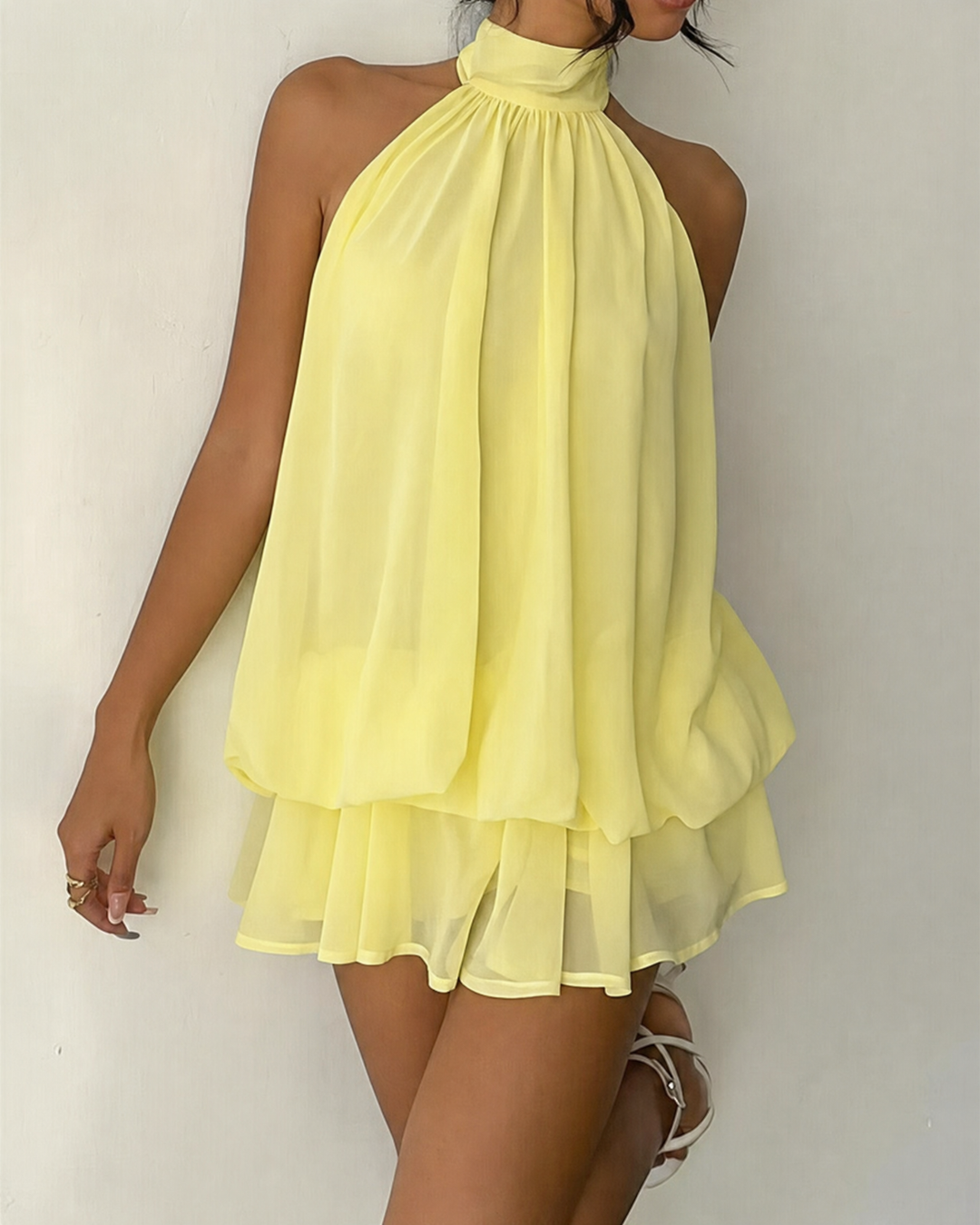 Chic casual women's mini dress, features a flowy tiered hem and halter neck.