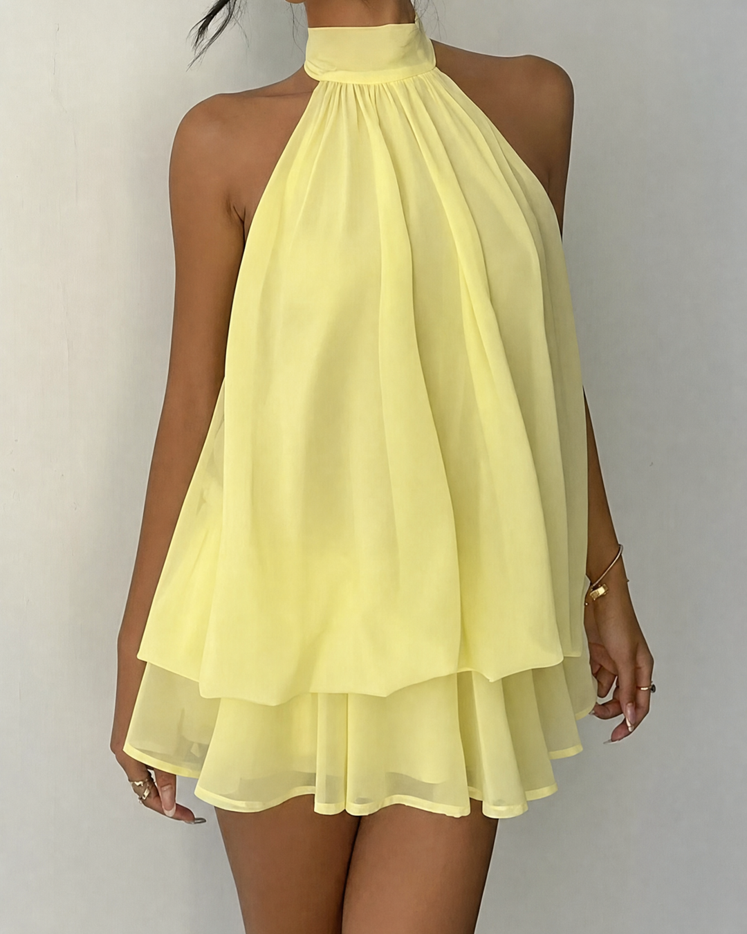 Women's flowy mini dress, a sleeveless halter neck design, ideal for parties.