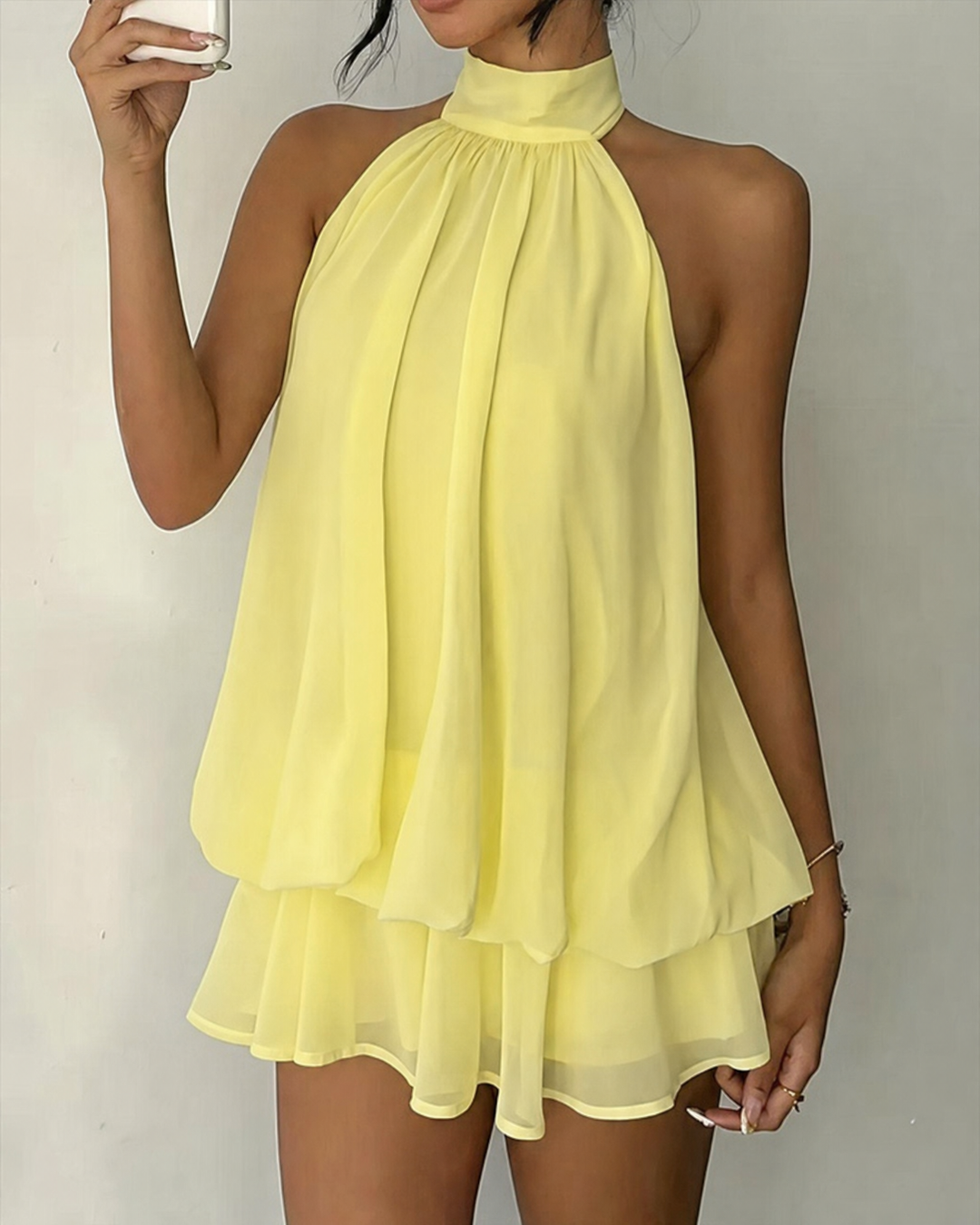 Women's flowy halter mini dress with tiered hem, perfect for summer parties.