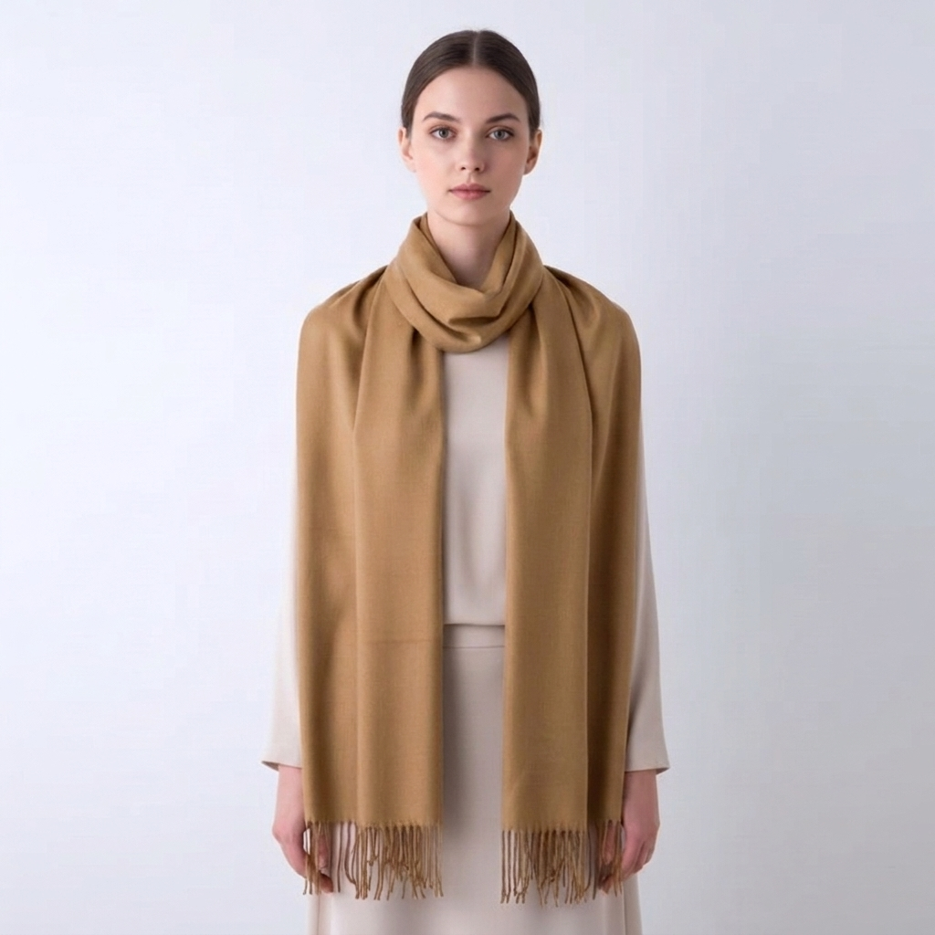 Keep warm with this women's solid winter scarf, a cozy wrap featuring a decorative tassel trim.
