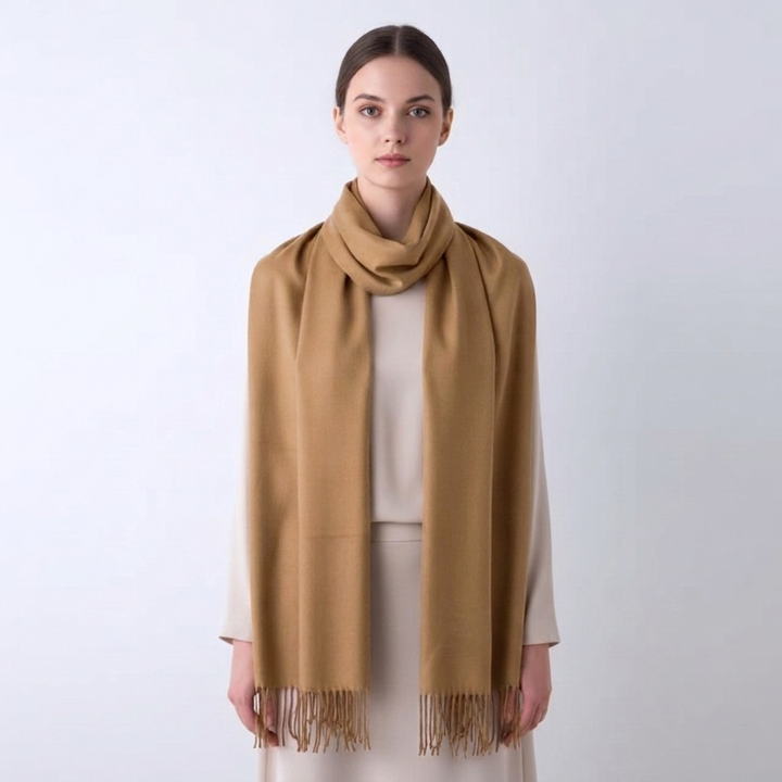 Keep warm with this women's solid winter scarf, a cozy wrap featuring a decorative tassel trim.