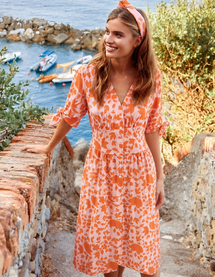 Women's orange floral midi spring dress with V-neck & button-front. Perfect for summer fashion & vacations.