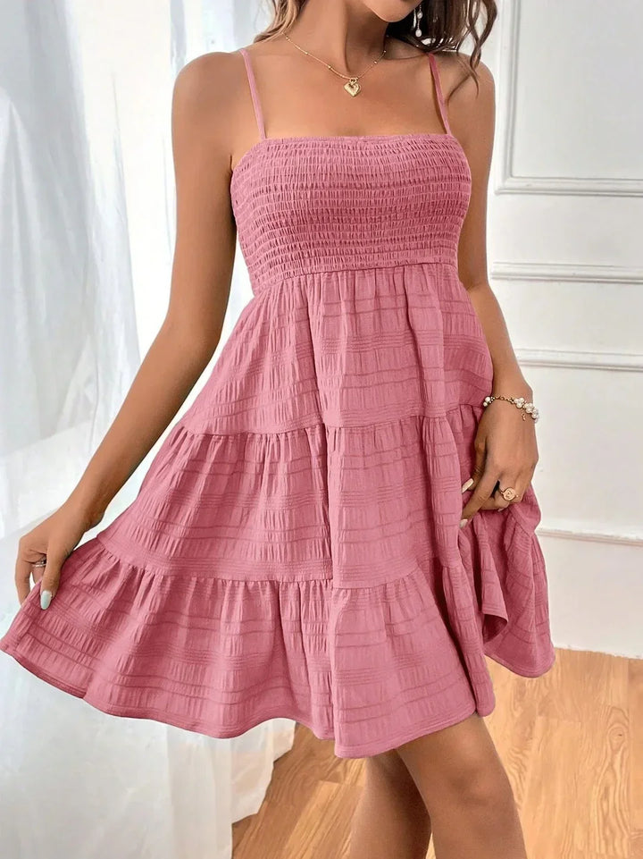 Sleeveless smocked mini summer dress for women with adjustable straps & playful tiered ruffle hem. Beach ready.