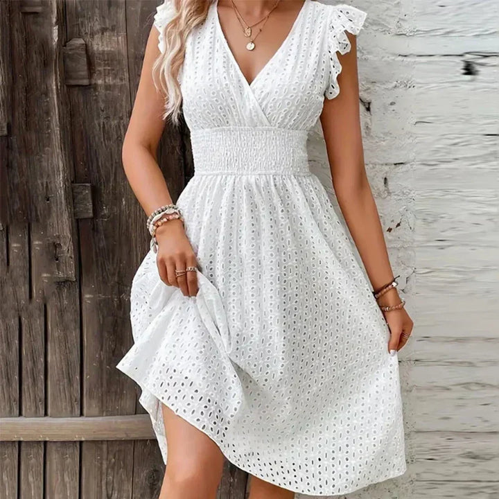 Women's white eyelet midi dress with V-neck, perfect for summer. Flowy, elegant design with ruffled sleeves.