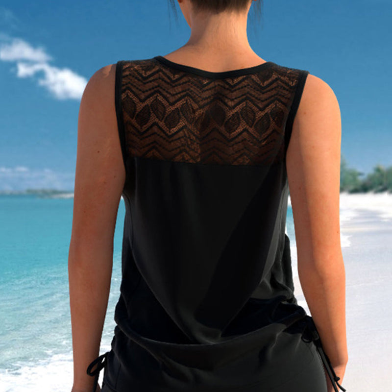 Woman sitting by pool in comfy women's criss-cross tankini & patterned shorts, summer style.