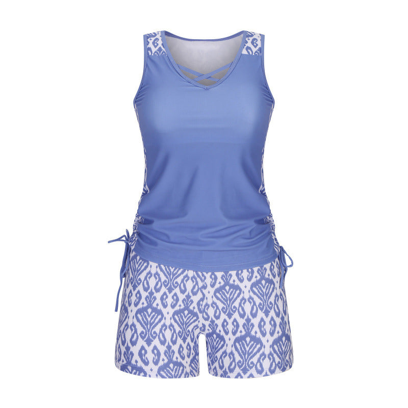 Flattering women's criss-cross tankini top & patterned shorts, chic beachwear for all body types.