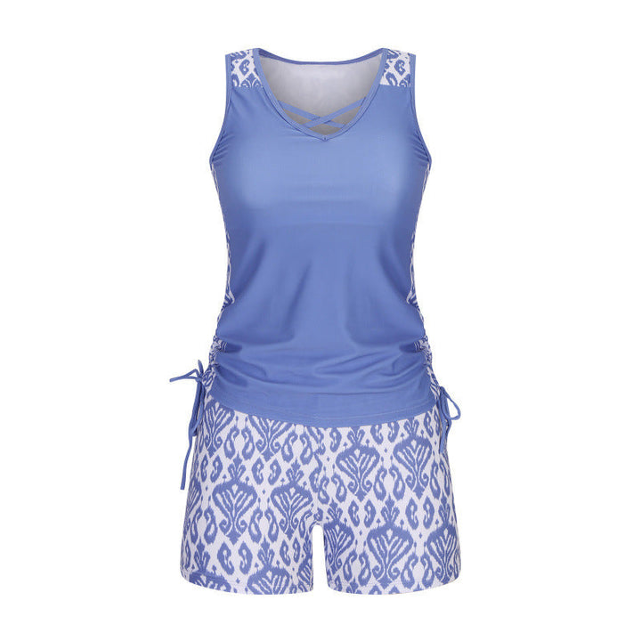 Flattering women's criss-cross tankini top & patterned shorts, chic beachwear for all body types.