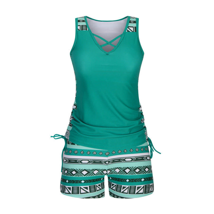 Modern women's tankini set: criss-cross top pairs with vibrant patterned shorts for summer beach.