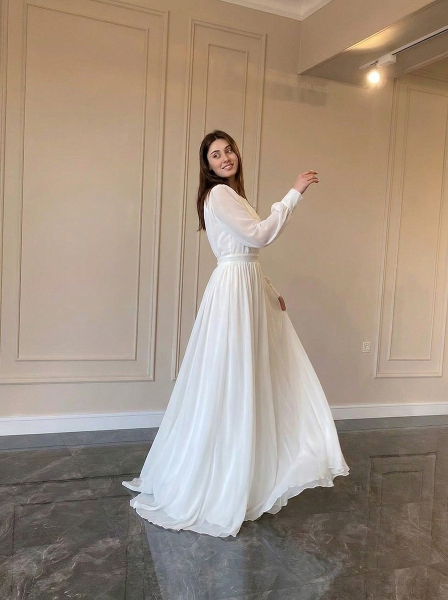 Flowy long sleeve white wedding dress for women. Elegant bridal gown, ideal for a modest and classic special occasion look.