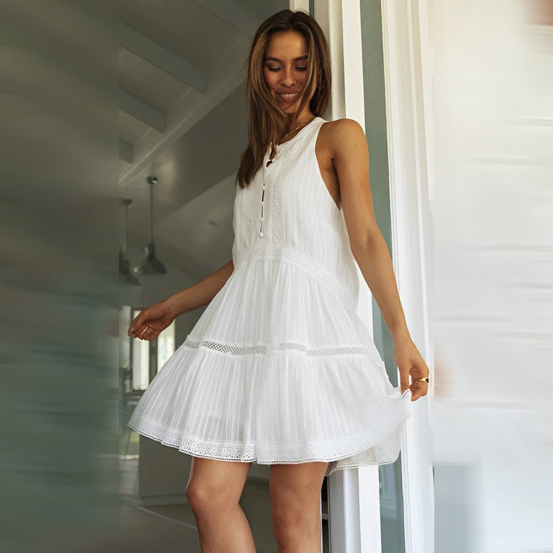 Chic white sleeveless boho mini dress featuring eyelet fabric and a stylish button placket. Ideal for summer vacations.