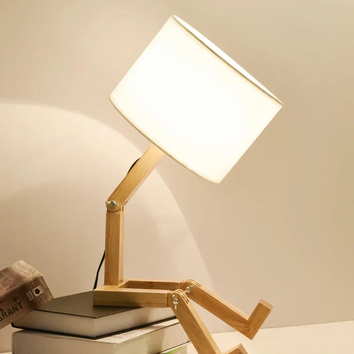 Playful wooden robot table lamp with integrated book holder. Perfect for kids' rooms or unique home lighting.