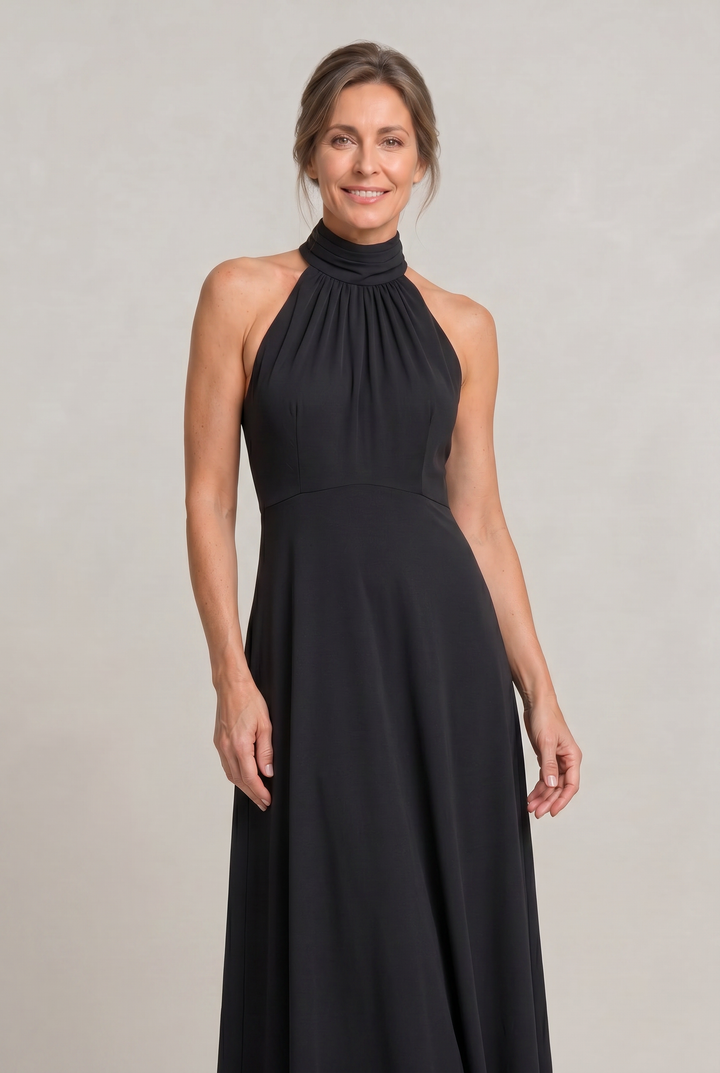 Sleeveless graceful women's halter neck maxi dress in black. A stunning A-line party and evening gown.
