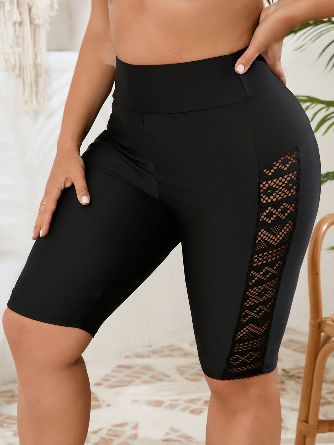 Dynamic shot of women's black high-waisted gym shorts with mesh panels, perfect for yoga, running, and training.